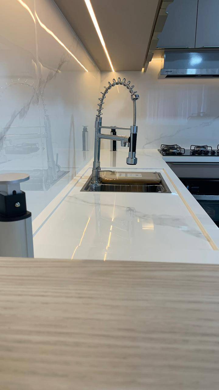 Cozinha sob medida com bancada em porcelanato e acabamento alinhado.